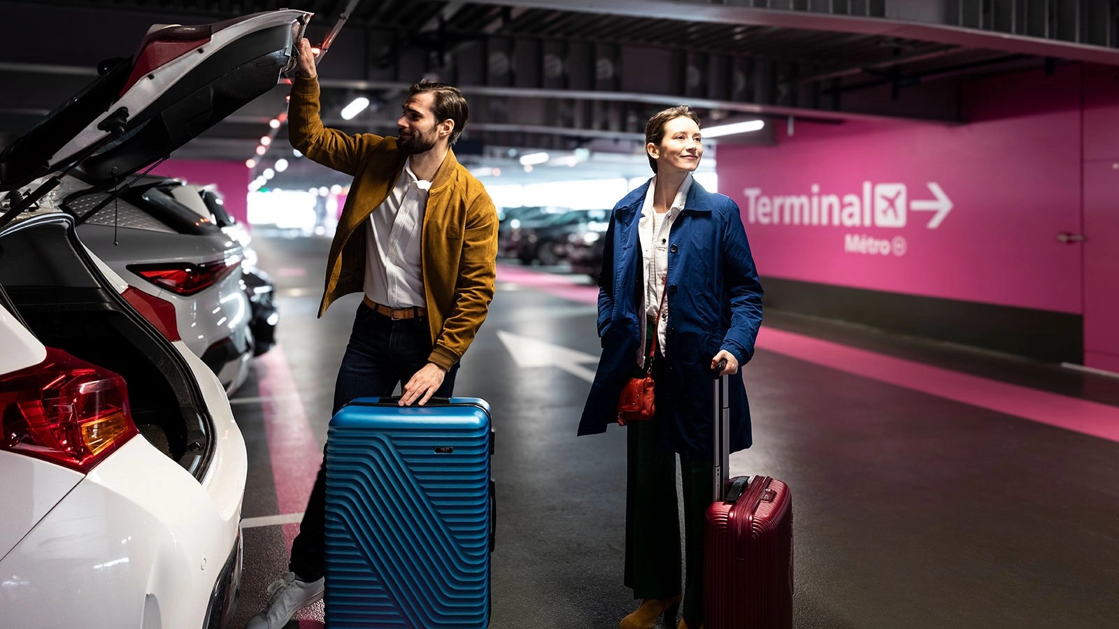 Un couple avec valises au parking officiel Paris Aéroport