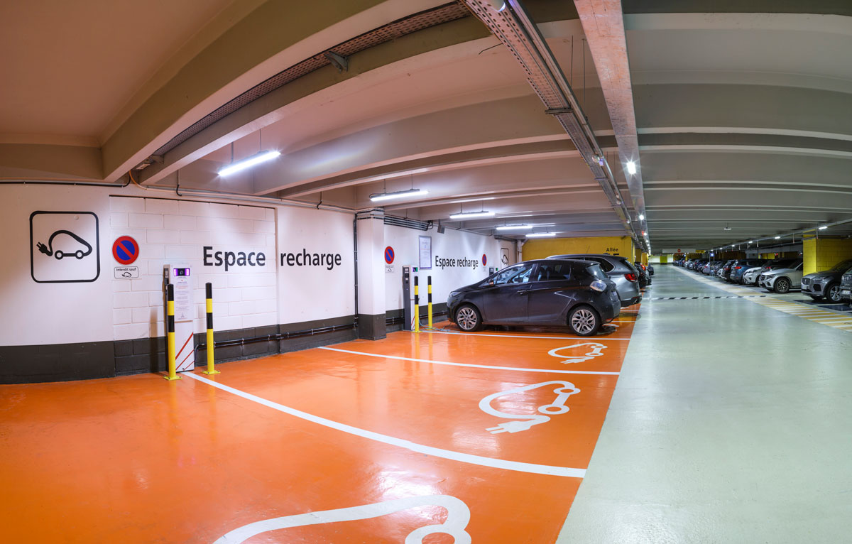 cars connected to electric terminals in a Paris Airport parking lot